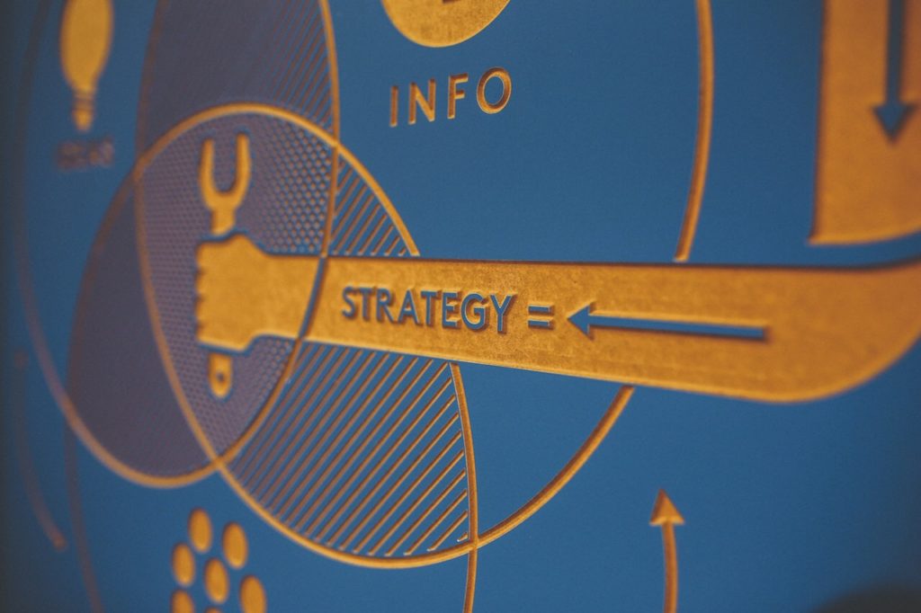 Blue sign that says strategy and info with icons like an arm holding a wrench and a lightbulb to symbolize the importance of improving your digital marketing strategy with good clean data quality