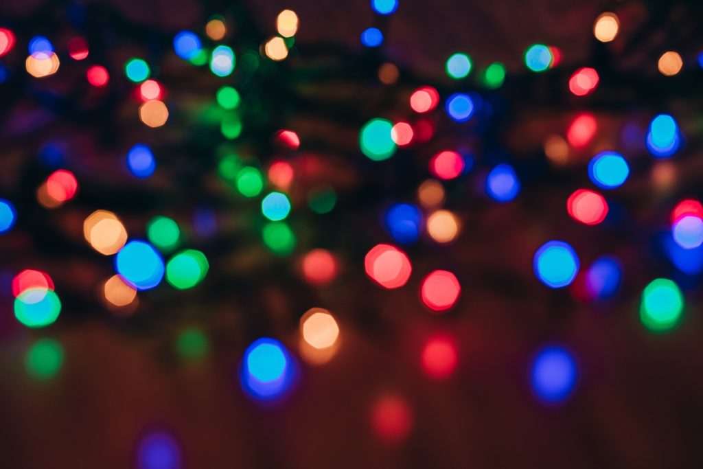 out of focus, multi-colored string lights on a dim background